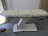 REM Excel Electric 3 Motor Beauticians Adjustable Treatment Chair/Couch Upholstered in White Vinyl and Comes with Controller, S/N 000182. NOTE: condition as viewed/pictured.