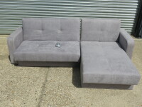 Kair L-Shape Sofabed Upholstered in Grey Fabric with Double Under-Seat Storage. Size H78 x W230 & 170 x D82cm. Ex Display. RRP £579.00. NOTE: small tear on fabric.