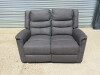Parma Loveseat Grey Fabric 2 Seater Recliner Sofa. Size H96 x W135 x D80cm. Ex Display. Note: small tear to fabric on cushion back.