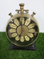 A Brass Mantle Clock with Roman Numeral Face and Glazed Image of a Compass on the Rear on Stand. Size Dia 20cm.