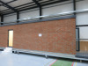 15.3m x 2.62m - Ex-Show Room Modular Housing Display Unit with Brick Front Finish, 2 Rendered Ends with Finish Required Top & Rear. Unit Sits on 2 x Sets of 6 Wheeled Galvanised Mobile Frames (7 x 3m). Fitted with Kitchen, Toilet, Shower room & Bedroom, A - 7