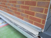 15.3m x 2.62m - Ex-Show Room Modular Housing Display Unit with Brick Front Finish, 2 Rendered Ends with Finish Required Top & Rear. Unit Sits on 2 x Sets of 6 Wheeled Galvanised Mobile Frames (7 x 3m). Fitted with Kitchen, Toilet, Shower room & Bedroom, A - 36