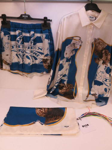 19 x MSGM Milano Long Sleeve Shirt & Matching Bermuda Shorts with Foulard in Cream, Blue & Gold to Include: 7 x Shirts, Size (38/40/40/42/42/44), RRP £425, 8 x Shorts, Size (38/38/38/40/40/42/44/46), RRP £295 & 2 x Foulard, RRP £195. Total RRP £5725.00.