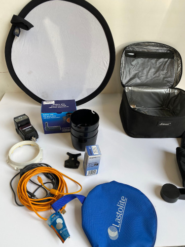 Zip Up Carrier with Assorted Camera Accessories, Including Nikon Flash and Nikon D200 Battery Grip.