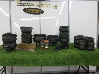 Lot of Potion Making Equipment to Include: 24 x Assorted Sized Cast Iron Cauldrons, 10 x Wands, 12 x Plastic Ladles, 3 x Egg Timers & 1 x Wooden Potion Making Sign.