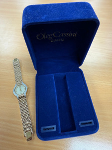 DMQ Swiss Movement Gold Tone Ladies Wrist Watch with Gemmed Bezel, Model DQ/N4074 in Oleg Cassini Box. NOTE appears unworn.