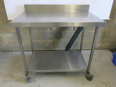 Stainless Steel Table on Castors with Part Splash Back & Shelf Under. Size H90 x W103 x D65cm.