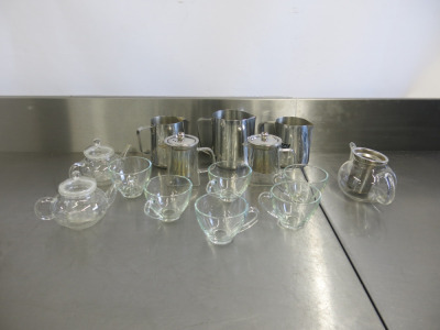 Quantity of Glass Tea Pots, Glasses & Stainless Steel Jugs to Include: 5 x Tea Pots, 6 Cups & 3 x Assorted Sized Jugs.