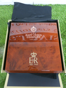 The East India Company Commemorative Queen Elizabeth 70th Jubilee Coin Collectors Box in Polished Wood with Gold Lettering and The Royal Cipher EIIR. Comes with 10 Coin Holder Insert & Pair of White Gloves. Size H9 x W 31 x D30cm.