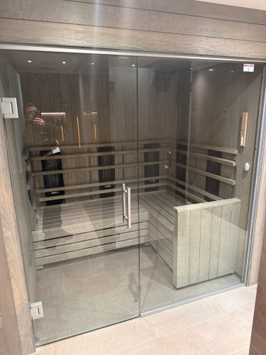 Harvia Fitted Sauna Unit with L Shape Seat Glass Door & Front. Size Approx 190 x 150 x H210cm. Located in Men's Changing Rooms. NOTE: Located on-site Kensington High Street, requires collection by appointment only. The buyer will be required to lodge &pound;100