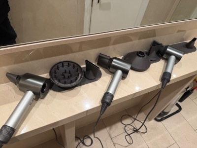 4 x Dyson Supersonic Airdryers with Attachments, Requiring Plugs (As Viewed).