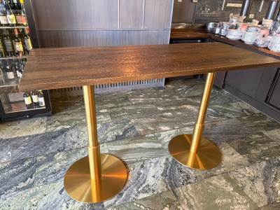 Dark Solid Wooden High Table on Twin Brass Coloured Base. Size H111 x D75 x W180cm.