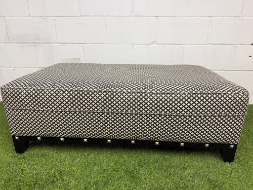 Large Rectangular Footstool in Black & White Geometric Pattern Upholstery with Metallic Stud Detail on Black Wooden Leg Base. Size H43 x W120 x D75cm.