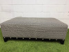 Large Rectangular Footstool in Black & White Geometric Pattern Upholstery with Metallic Stud Detail on Black Wooden Leg Base. Size H43 x W120 x D75cm.