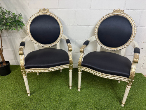 Pair of Louis XVI Style Carved Gilt Armchairs in White with Gold Painted Detail & Royal Blue Satin Upholstery with Three Rose Finial to Top.