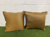 2 x Dark Gold with Black Faux Leather Trim Feather Filled Cushions. Size 50 x 50cm.