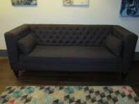 3 Seater Sofa Upholstered in Dark Grey Fabric with 2 Cushions, Button Back & Stud Detail on Black Wooden Legs. Size H83cm x W200cm x D85cm.