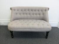 2 Seater Curved Back Sofa, Upholstered in Grey Button Back Fabric on Matt Black Turned Front Legs. Size H74cm x W110cm x D60cm.