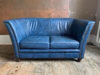 High Back 2 Seater Sofa Upholstered in Blue Faux Leather with Stud Detail & Wooden Feet. Size H80cm x W150cm x D80cm.